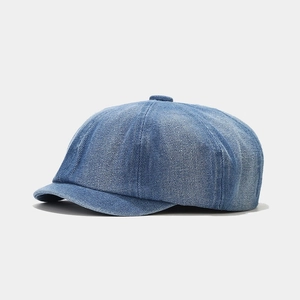 Close-up of blue denim octagonal cap showing twill texture and decorative top button