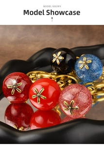 Close-up of glitter resin spherical keychains with floral caps on a mirror tray