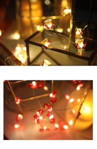 Macro shot of warm white LED string lights with golden bells and candy cane shapes