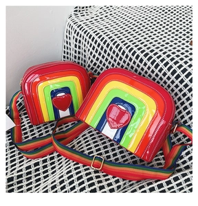 Detail of rainbow crossbody bag with heart patch and adjustable woven shoulder strap