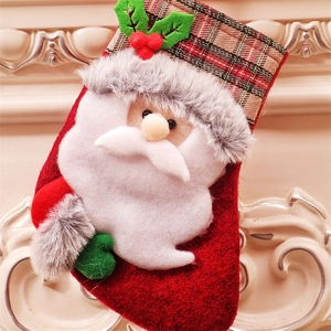 Détail d'une chaussette de Noël rouge avec figurine de Père Noël et bordure en écossais