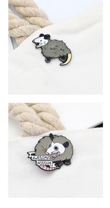 Detail of enamel opossum pins on canvas featuring Awesome Possum text design