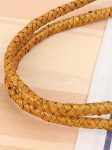 Handcrafted woven straw shoulder bag with natural fiber texture and rustic forest style