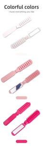 Close-up of portable folding hairbrush with mirror in white, pink and rose red