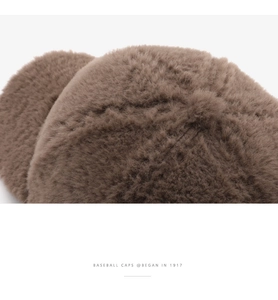 Close-up detail of brown plush baseball cap fabric showing warm teddy wool texture