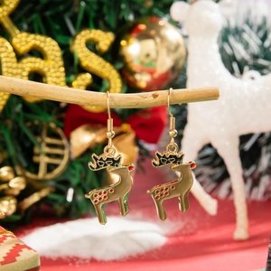 Detailed view of reindeer earrings with brown enamel finish on a festive Christmas branch