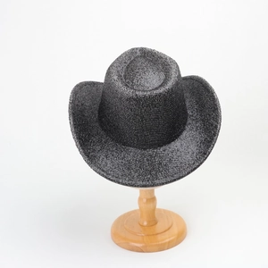 Detail of silver black sequin cowboy hat texture on wooden ball stand in studio light