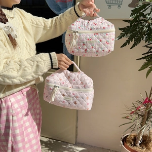 Detailed macro view of quilted floral and bear pattern cotton cosmetic bags with zip closure