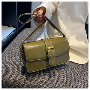Close-up of olive green vintage leather crossbody bag on a textured grey surface