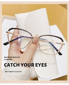 Detailed view of cat-eye glasses frame with gold metal temples and black accents