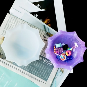 Detail of octagonal silicone mold with purple resin bowl and various cute craft charms