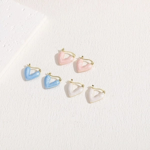 Detailed view of three pairs of enamel heart earrings in blue pink and white marble textures