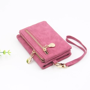 Detail of pink faux suede wallet for women featuring multiple zippers and a wrist strap