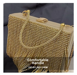 Close-up of golden rhinestone tassel clutch with metallic frame and luxury chain strap