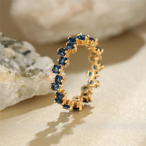 Detailed macro view of gold-plated eternity ring with square blue zircon channel setting