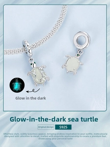 Detailed close-up of S925 silver sea turtle charm with luminous shell and green stone eyes