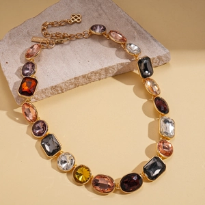 Detailed macro view of retro gold sweater chain with multicolor crystal geometric pendants