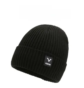 Detail of black winter knit beanie featuring a V SPORTS square woven label and ribbed texture