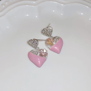 Macro shot of silver heart earrings with pink enamel flowers and small pearl detail
