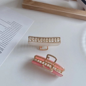 Elegant rectangle acetate hair claws in beige and pink with gold metal accents and trim