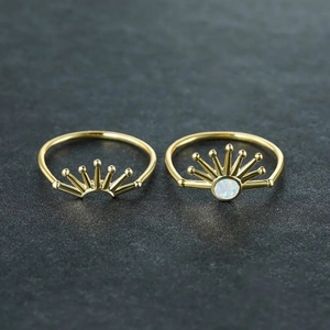 Macro detail of sunrise series gold rings featuring sunburst design and white opal stone