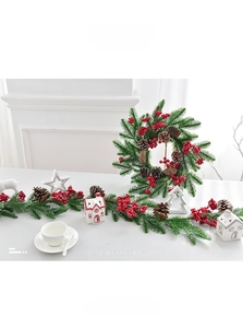Detailed view of Christmas wreath and vine with red berries and pine cones on table