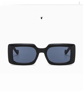 Détail de lunettes de soleil rectangulaires noir brillant avec verres gris foncé style C01
