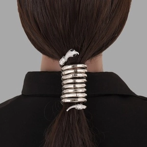 Detailed view of silver snake-shaped metal hair coils wrapped around a ponytail