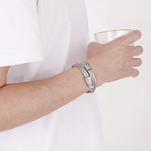 Detail of silver punk dragon head bangle with double wire cables on male wrist