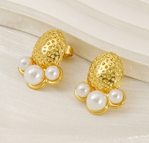 Detailed view of gold plated hammered texture earrings featuring three white pearls