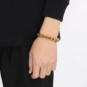 Détail d'un bracelet chaîne impériale dorée au poignet masculin avec motifs précis