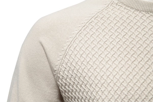 Detail of beige knit sweater showing refined texture and shoulder stitching craftsmanship