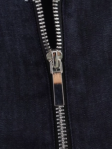 Close-up of high-quality metal zipper and textured dark blue denim on vintage jacket