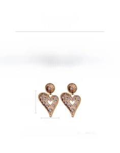 Macro view of oversized heart earrings with hammered texture and rhinestone details