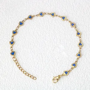 Dettaglio di catena in acciaio dorato con cuori in smalto blu e chiusura a moschettone