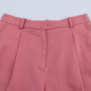 Detail of pink linen blend tailored shorts featuring waist pleats and belt loops