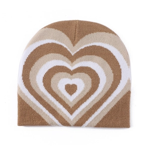 Macro detail of brown and beige heart pattern knit beanie with soft wool texture