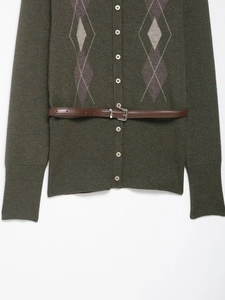Dettaglio cardigan in maglia verde scuro con motivo argyle e sottile cintura in pelle
