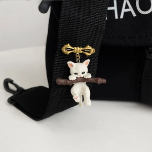 Golden bow brooch with cute white resin cat on a branch for backpack and suit decoration