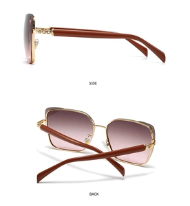 Detail view of gold metal sunglasses with brown gradient lenses and crystal hinge