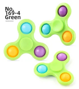 Three-arm green fidget spinner toy with colorful silicone pop bubbles in macro view