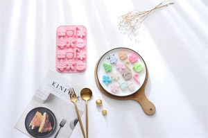 Detailed view of pink 15-cavity Christmas silicone mold with snowman and tree shapes