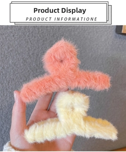 Detail of plush faux fur hair claw clips in pink-orange and beige for autumn and winter