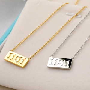 Gold and silver stainless steel 11:11 angel number pendant necklaces on a velvet display