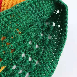 Handmade crochet wheat ear beanie with vibrant green, yellow, and red yarn textures
