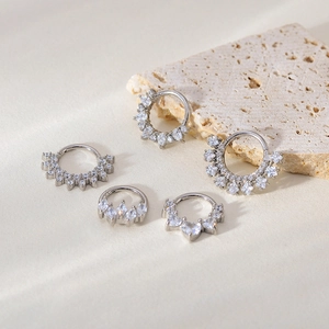 Five assorted silver seamless nose rings with cubic zirconia on textured stone base