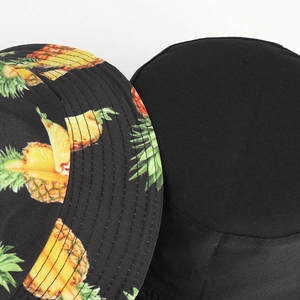 Reversible bucket hat with vibrant tropical pineapple print and solid black cotton finish