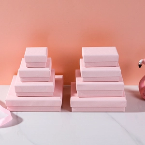 Elegant pink cross-pattern jewelry gift boxes in various sizes on marble surface