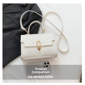 White croc-embossed handbag with gold hardware next to a smartphone for size reference