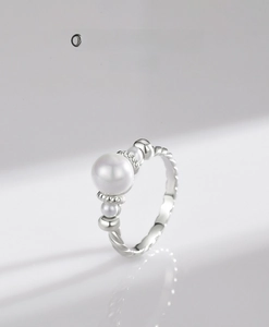 Detail of S925 silver pearl ring featuring twisted rope texture and central bead design